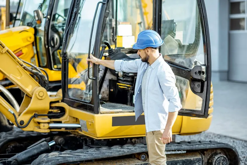 Appraiser evaluating a heavy-duty excavator at a construction site