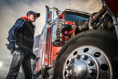 Appraiser inspecting a damaged semi-truck at a fleet yard